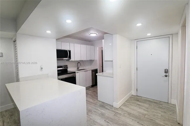 a large kitchen with kitchen island a sink stainless steel appliances and cabinets