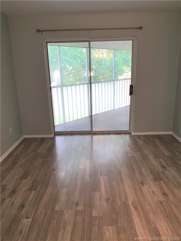 3302 Southeast Aster Lane Stuart, FL 34994 - Photo 11 of 19 a view of an empty room with wooden floor and a window