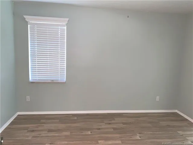 a view of a small space with wooden floor and a window