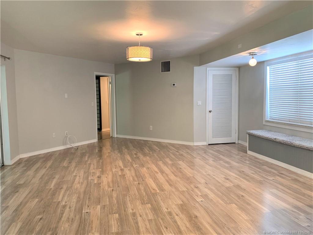 3302 Southeast Aster Lane Stuart, FL 34994 - Photo 4 of 19 an empty room with wooden floor and windows