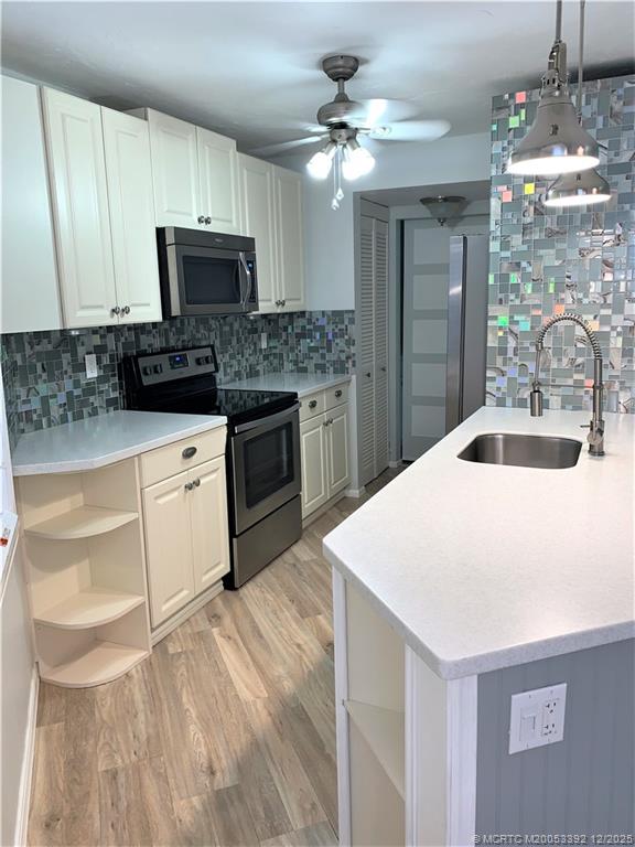 3302 Southeast Aster Lane Stuart, FL 34994 - Photo 6 of 19 a kitchen with granite countertop a sink stainless steel appliances and white cabinets