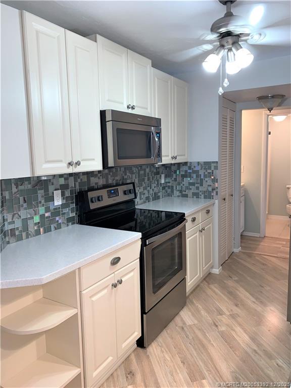 3302 Southeast Aster Lane Stuart, FL 34994 - Photo 7 of 19 a kitchen with stainless steel appliances granite countertop a stove a sink and a microwave