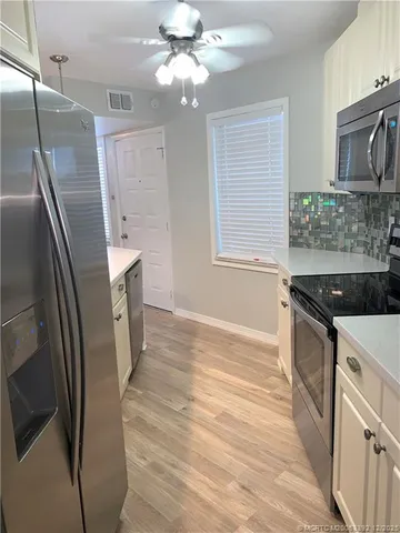 a kitchen with stainless steel appliances granite countertop a refrigerator a stove a sink and a refrigerator