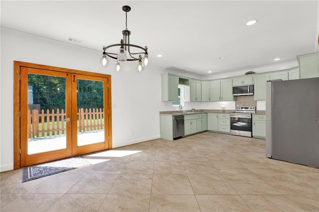 2794 Cleburne Parkway Powder Springs, GA 30127 - Photo 13 of 49 a view of a kitchen with a stove cabinets a ceiling fan and wooden floor