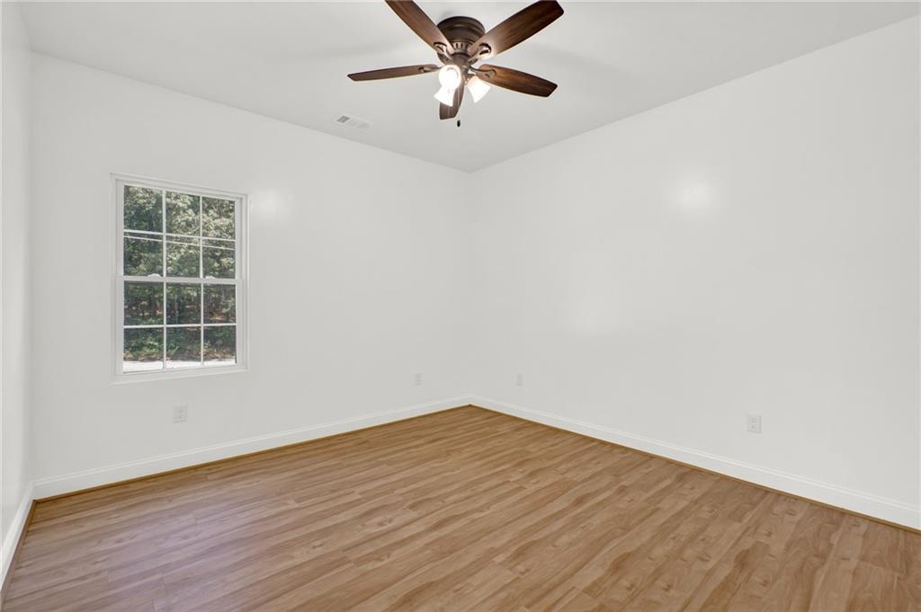 2794 Cleburne Parkway Powder Springs, GA 30127 - Photo 30 of 49 an empty room with wooden floor fan and windows