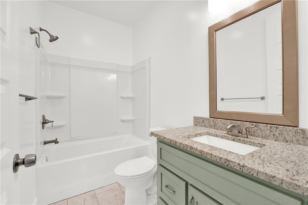 2794 Cleburne Parkway Powder Springs, GA 30127 - Photo 32 of 49 a bathroom with a granite countertop sink a toilet and bathtub
