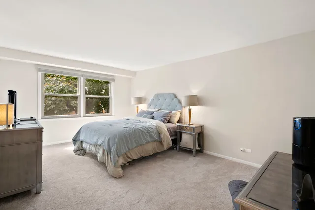 a spacious bedroom with a bed and a flat screen tv