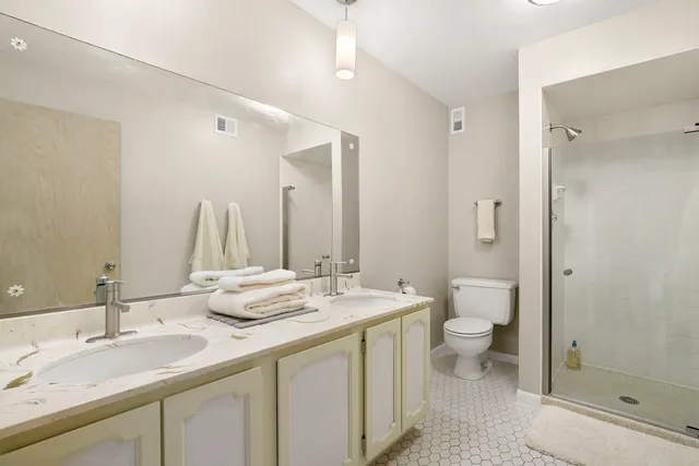 a bathroom with a double vanity sink a toilet and a mirror