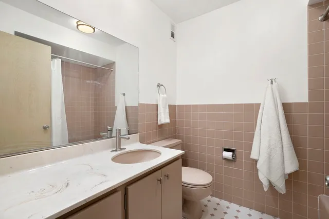 a bathroom with a sink toilet and mirror