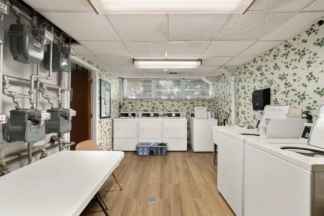 a kitchen with stainless steel appliances a white stove top oven a sink dishwasher and a refrigerator with wooden floor