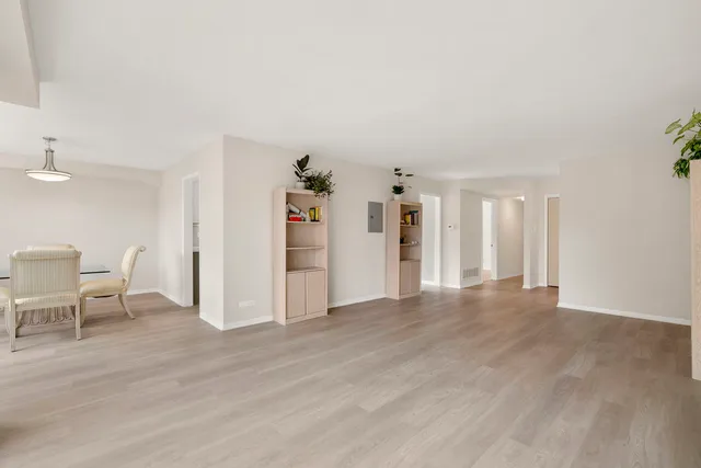 a view of a livingroom with wooden floor and furniture