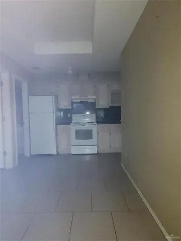 a kitchen with a refrigerator and a stove top oven