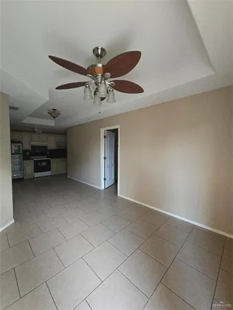 a view of an empty room and kitchen