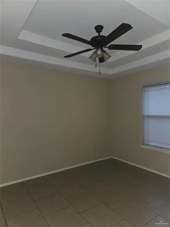 an empty room with a ceiling fan and a window