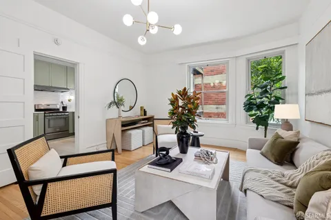 a living room with furniture a potted plant and a window