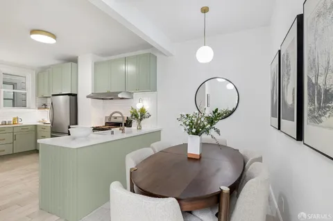 a kitchen with a table chairs and white cabinets