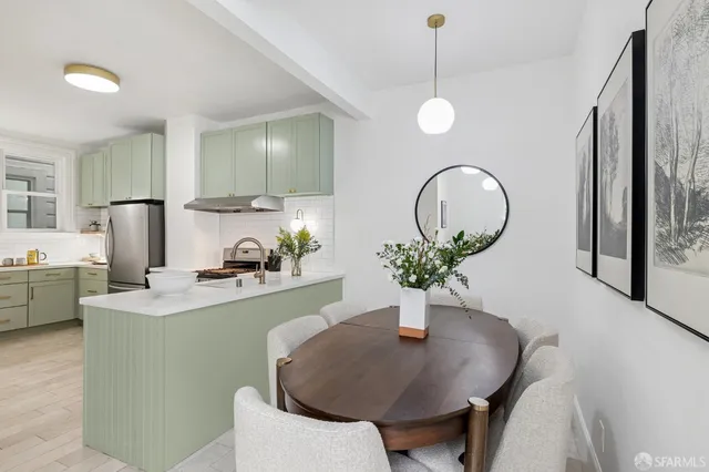a kitchen with a table chairs and white cabinets