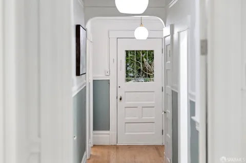 an entryway with wooden floor mirror