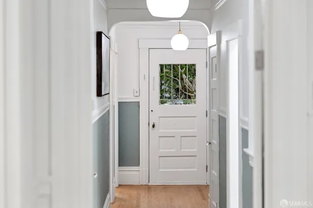 an entryway with wooden floor mirror