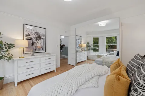 a bedroom with furniture and large mirror