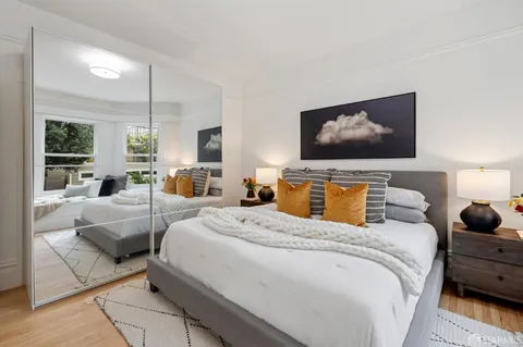 a bedroom with bed and large flat screen tv