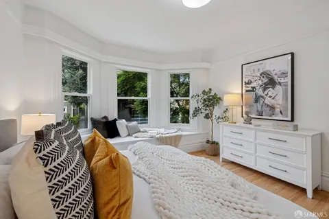 a bed room with a bed and a painting on the wall