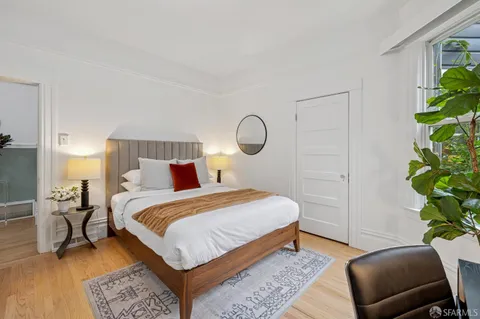 a bedroom with a bed lamp and a potted plant