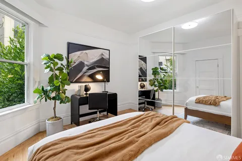 a bedroom with a bed and a potted plant