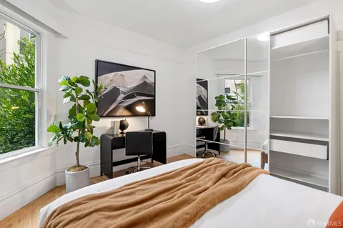 a bedroom with a bed and a potted plant