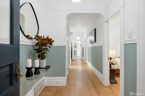 a view of a hallway with wooden floor and entryway