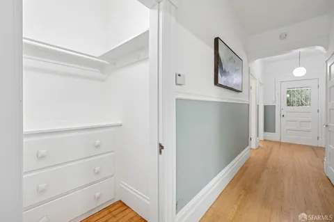 a view of a hallway with wooden floor and closet