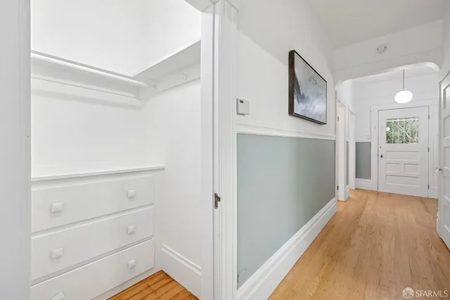 a view of a hallway with wooden floor and closet