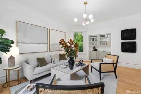 a living room with furniture a flat screen tv and a potted plant