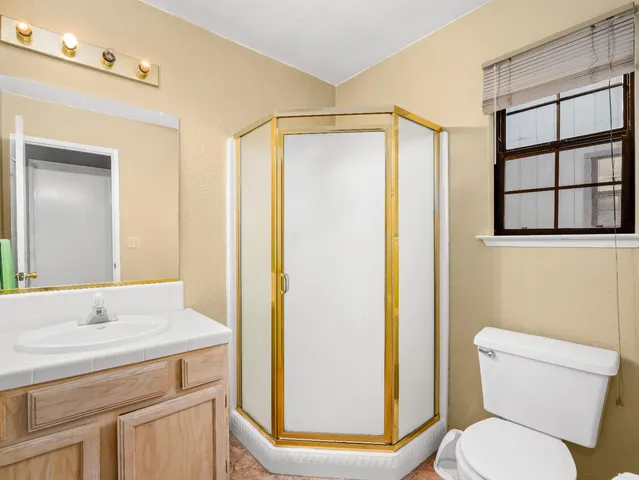 a bathroom with a granite countertop sink toilet and shower