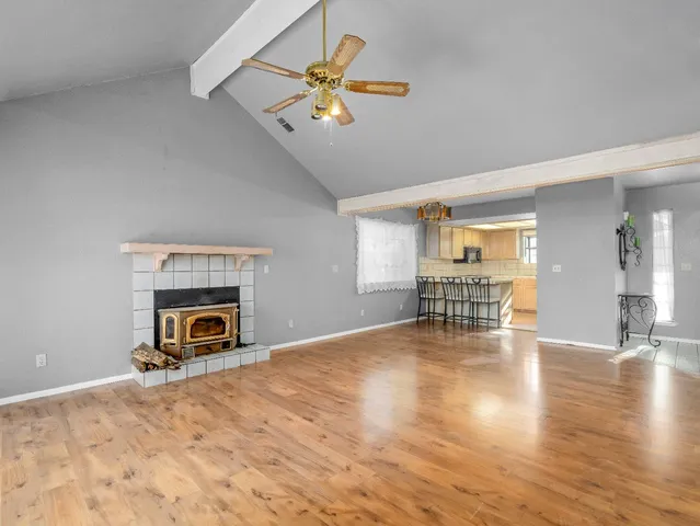 a view of empty room with wooden floor and fireplace