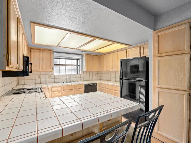 a kitchen with stainless steel appliances a refrigerator and a stove top oven