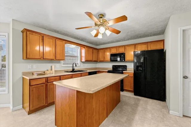 a kitchen with stainless steel appliances granite countertop a refrigerator and a sink