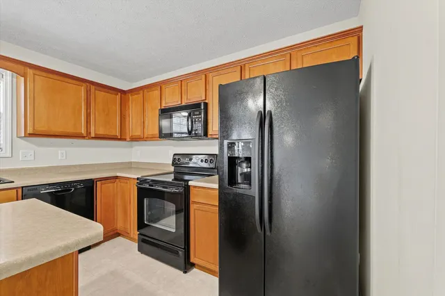 a kitchen with stainless steel appliances granite countertop a refrigerator a stove top oven a sink and dishwasher