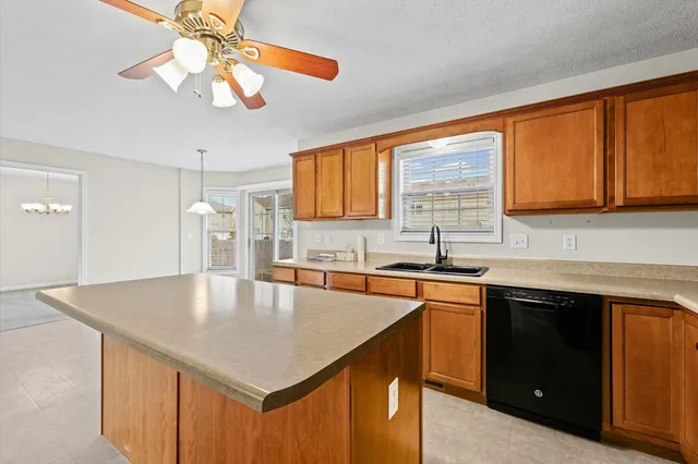 a kitchen with stainless steel appliances granite countertop a sink a microwave cabinets and island
