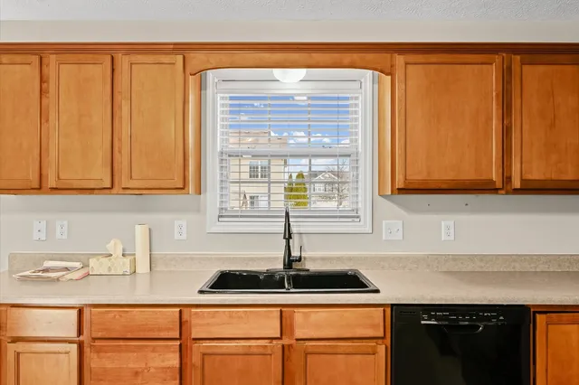 a kitchen with stainless steel appliances granite countertop a sink a refrigerator and a cabinets
