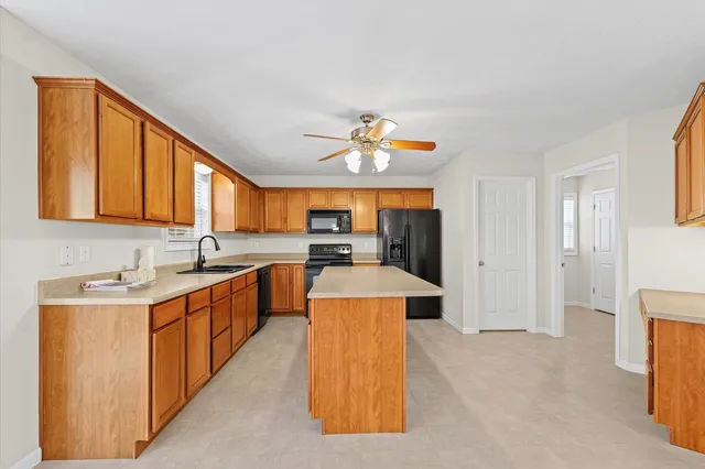 a large kitchen with stainless steel appliances granite countertop a sink and cabinets