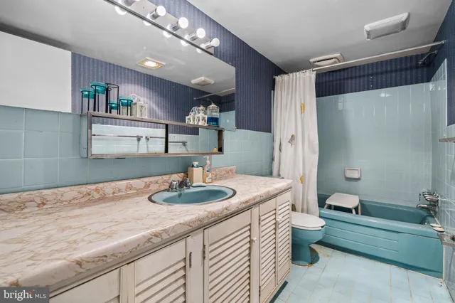 a bathroom with a granite countertop sink a mirror and a bathtub