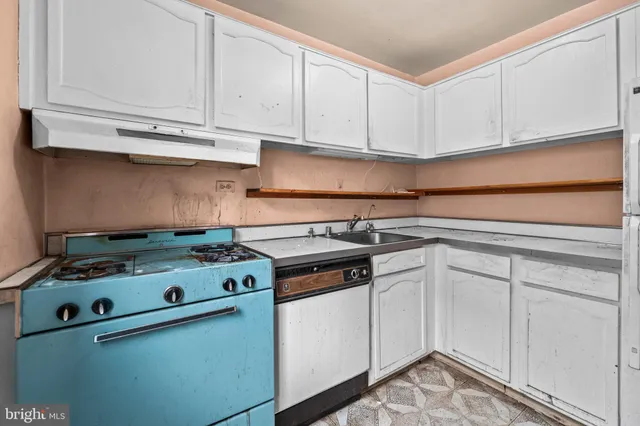 a white stove top oven sitting inside of a kitchen