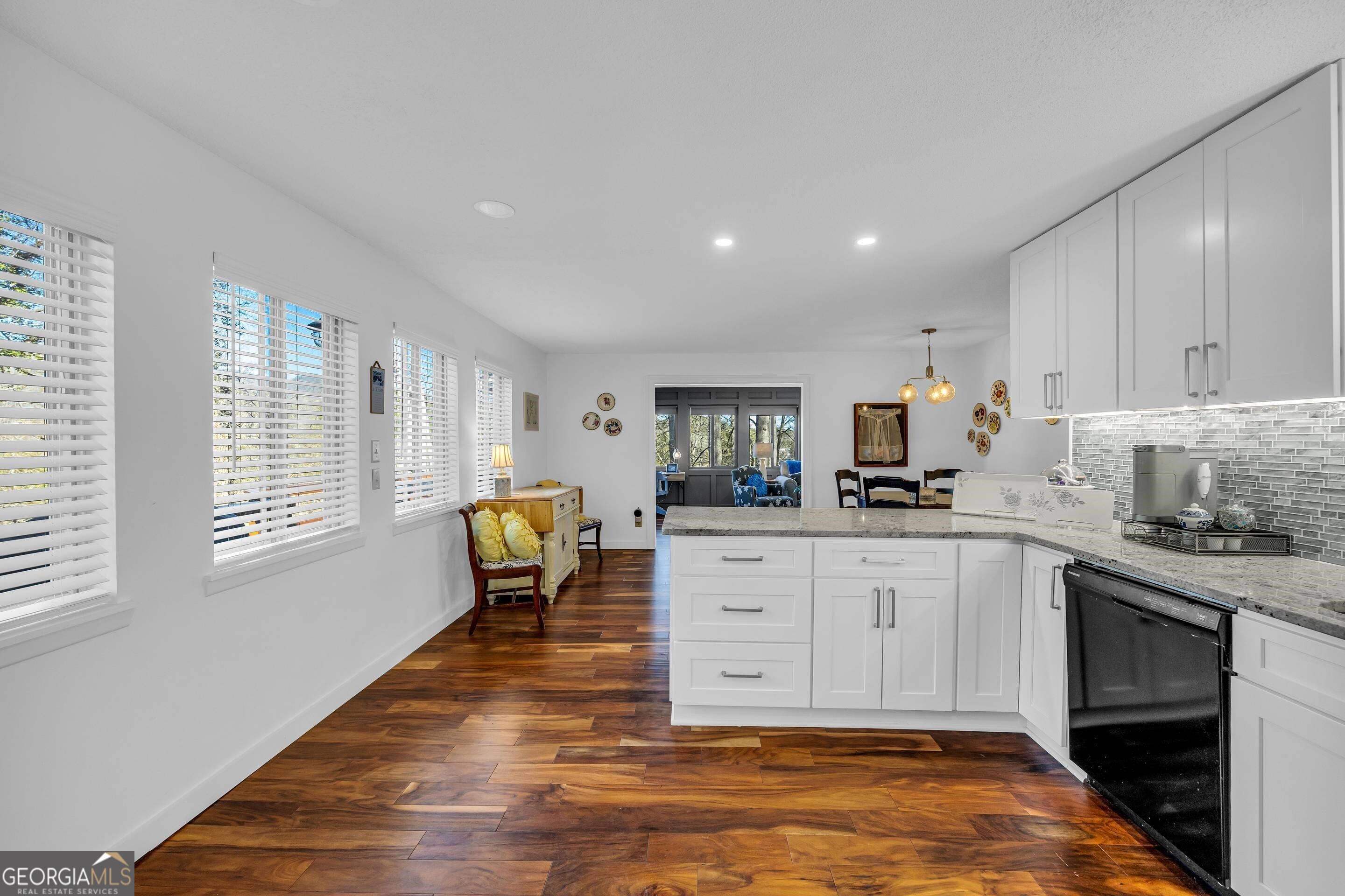 153 Coleman Heights Lane Rabun Gap, GA 30568 - Photo 18 of 57 a kitchen with stainless steel appliances granite countertop a stove a sink and white cabinets with wooden floor