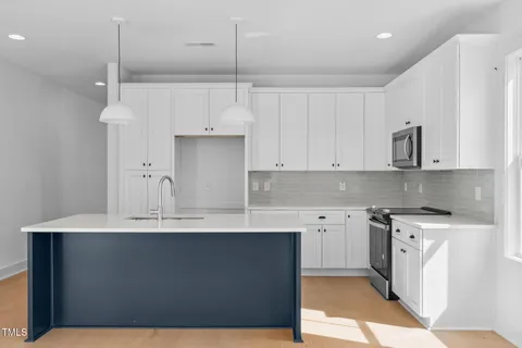 a kitchen with a sink dishwasher and white cabinets