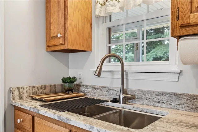 a kitchen with granite countertop a sink and a stove