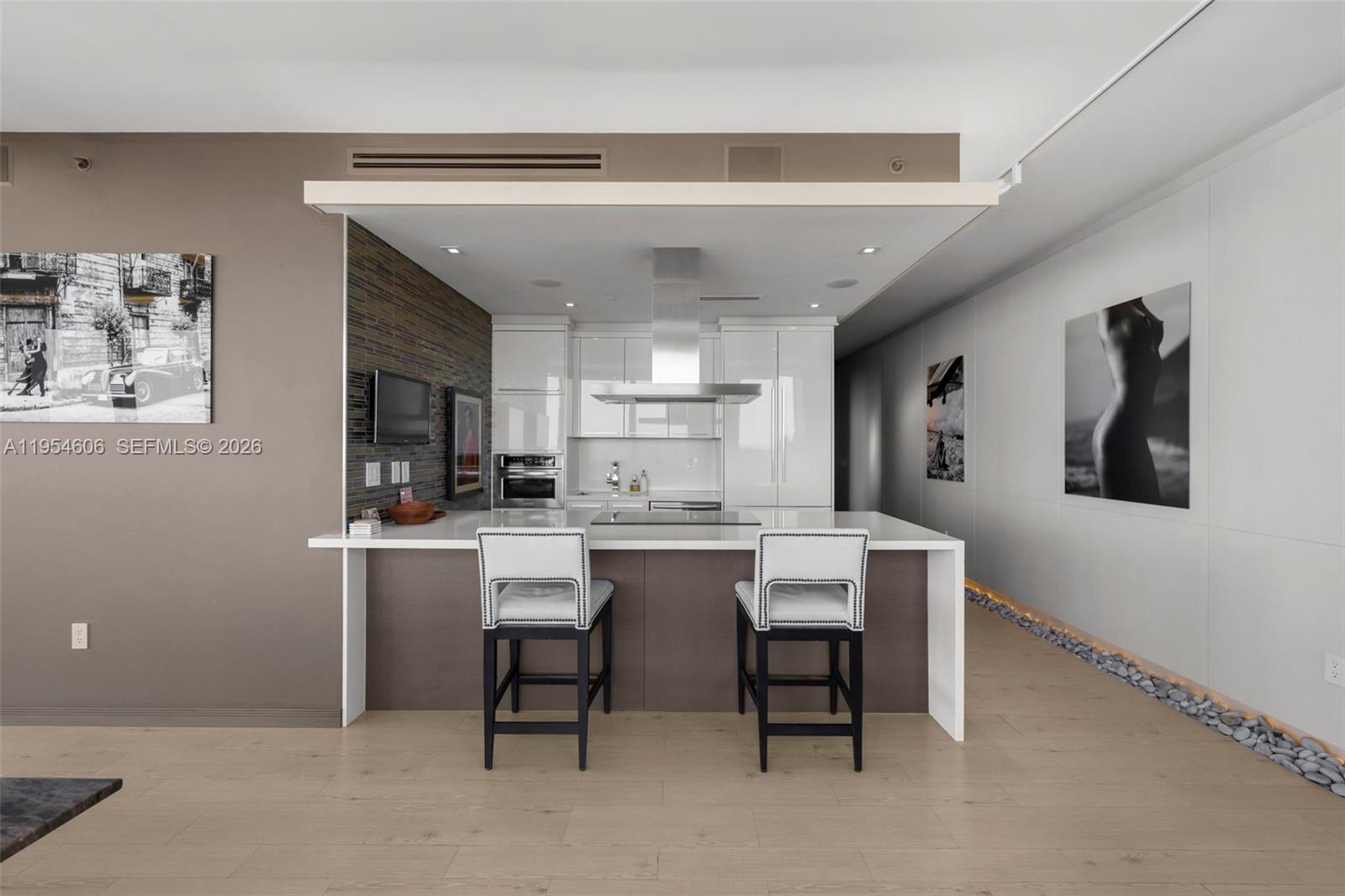 5875 Collins Avenue, Unit PH7 Miami Beach, FL 33140 - Photo 20 of 49 a kitchen with a sink and chairs