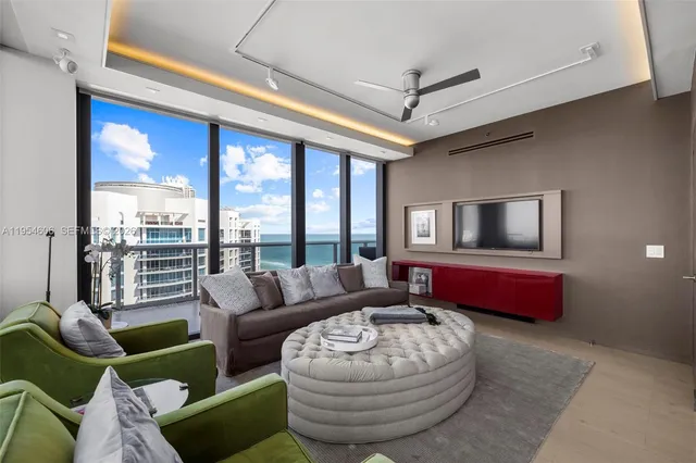 a living room with furniture and a floor to ceiling window