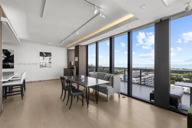 a dining room with furniture and a floor to ceiling window