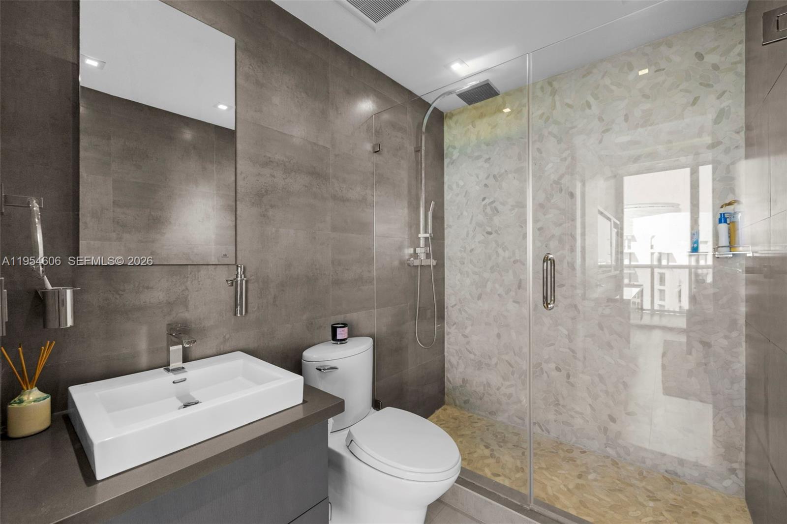 5875 Collins Avenue, Unit PH7 Miami Beach, FL 33140 - Photo 29 of 49 a bathroom with a toilet a sink and a mirror